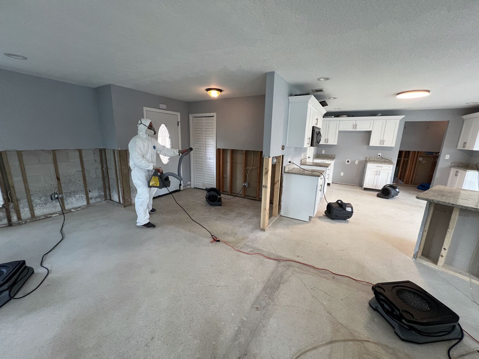 Technician applying antimicrobial treatment during water mitigation