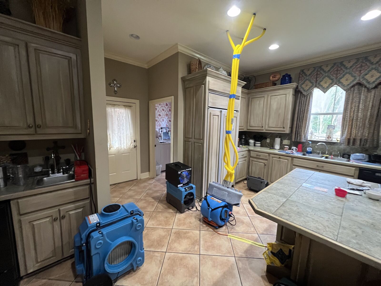 Air movers and dehumidifier drying kitchen after water damage