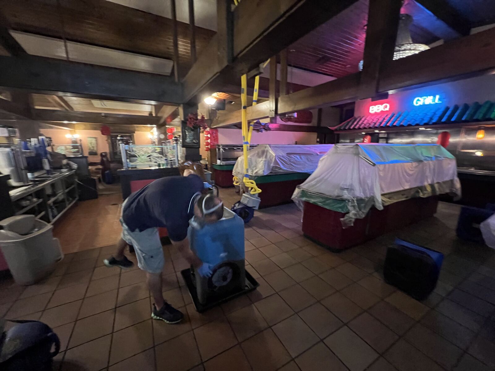 Technician operating drying equipment in restaurant dining room