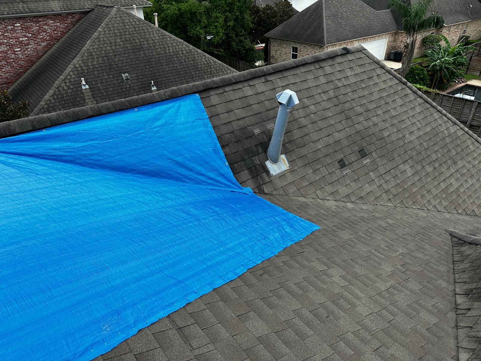 Silver emergency tarp installed across full roof section
